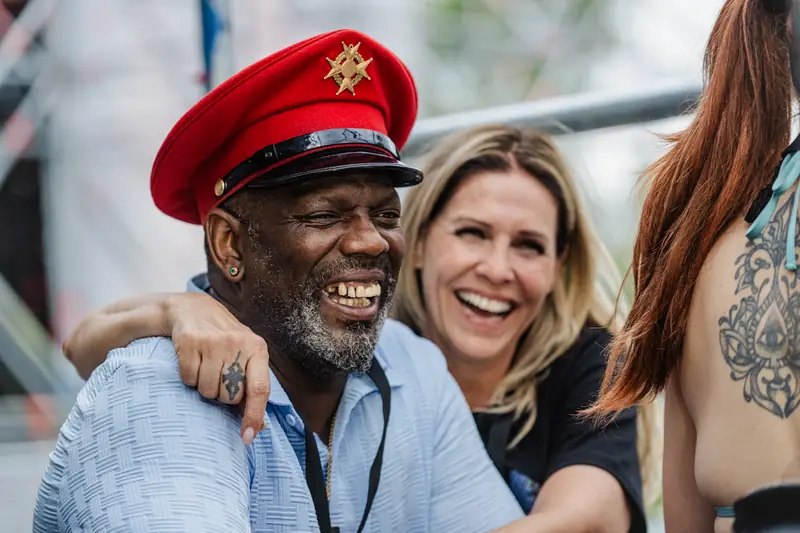 Artist in a captain's hat with a fan